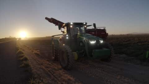 A tractor drives through a potato field at 4-D Farms at dawn.